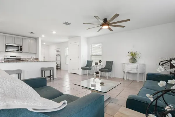 a living room with furniture kitchen view and a dining table