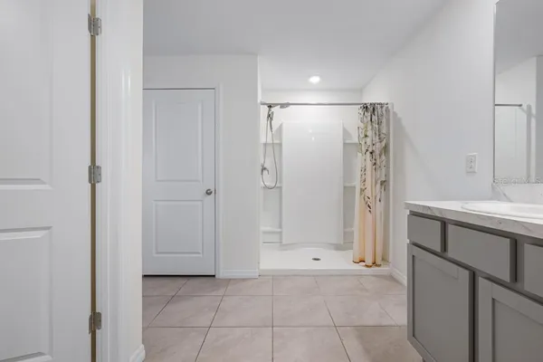 a view of an empty room with closet and a bathroom