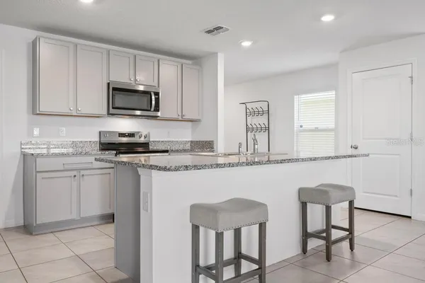 a kitchen with stainless steel appliances granite countertop a stove a sink and a refrigerator