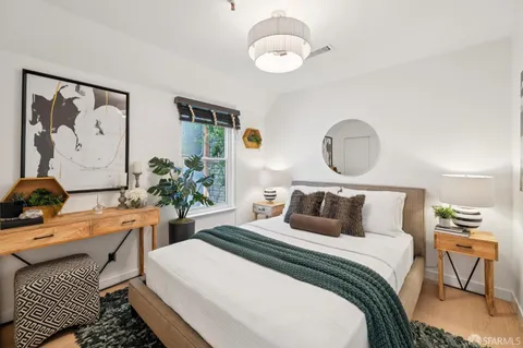 a bedroom with bed and wooden floor