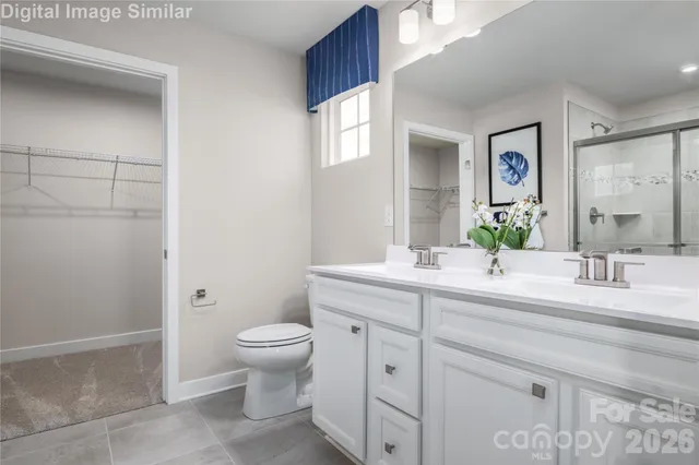 a spacious bathroom with a double vanity sink toilet and a mirror