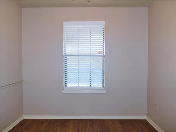 an empty room with wooden floor and a window