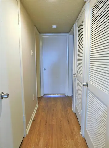 a view of a hallway with wooden floor