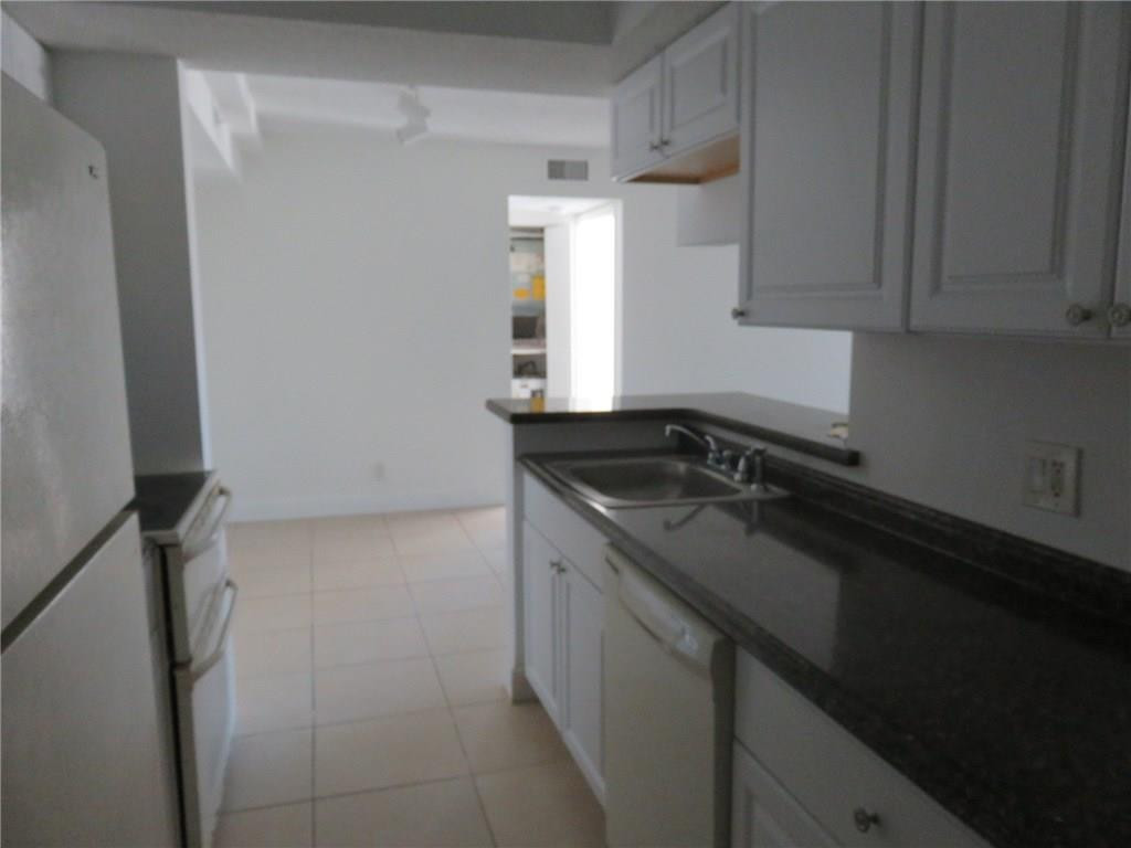 5672 Rock Island Road, Unit 239 Tamarac, FL 33319 - Photo 12 of 16 a kitchen with a sink and cabinets