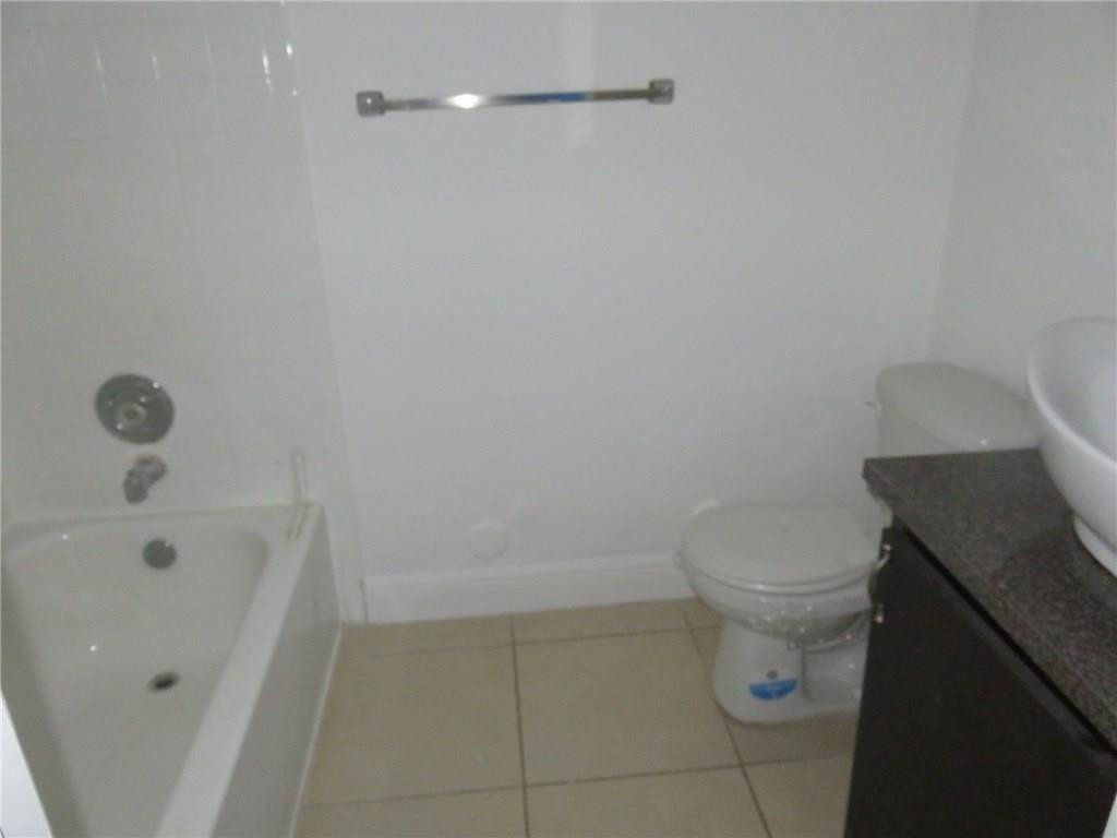 5672 Rock Island Road, Unit 239 Tamarac, FL 33319 - Photo 2 of 16 a white toilet sitting next to a bath tub