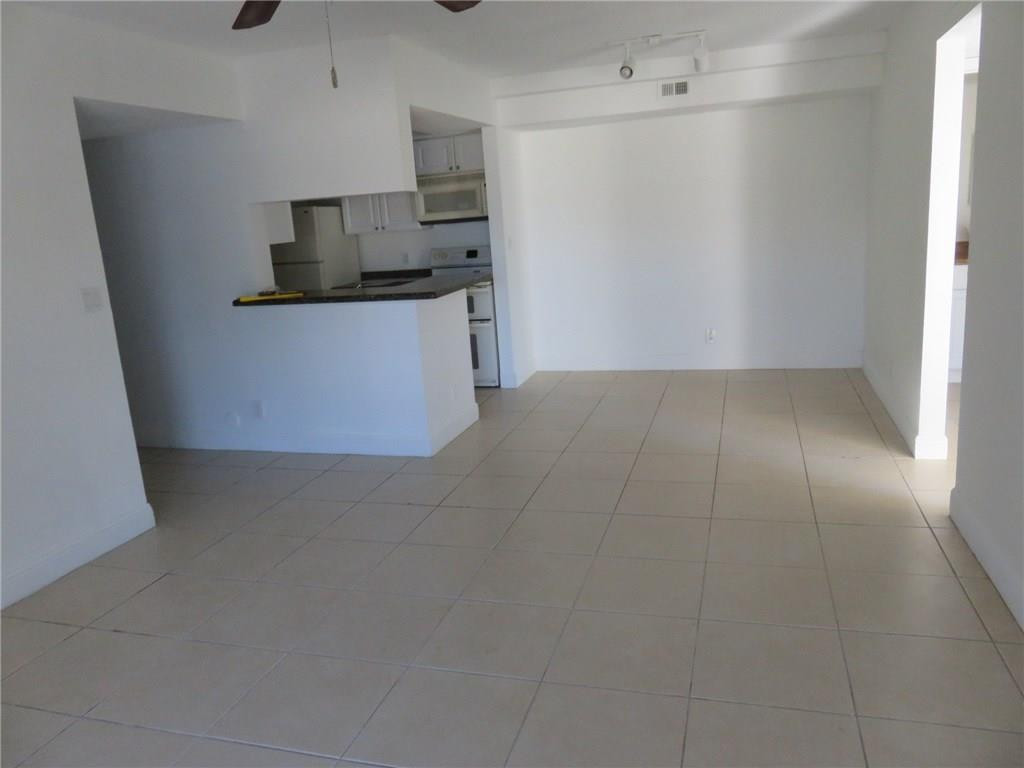5672 Rock Island Road, Unit 239 Tamarac, FL 33319 - Photo 5 of 16 a view of a kitchen with microwave and cabinets