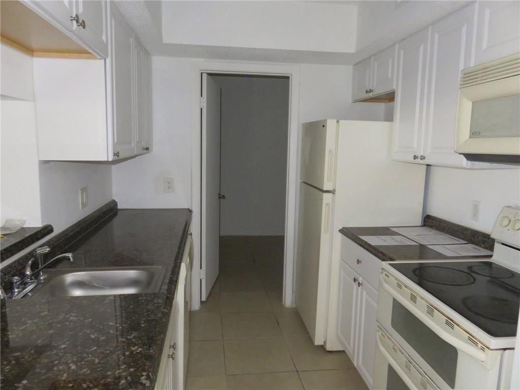 5672 Rock Island Road, Unit 239 Tamarac, FL 33319 - Photo 10 of 16 a kitchen with a stove and a refrigerator