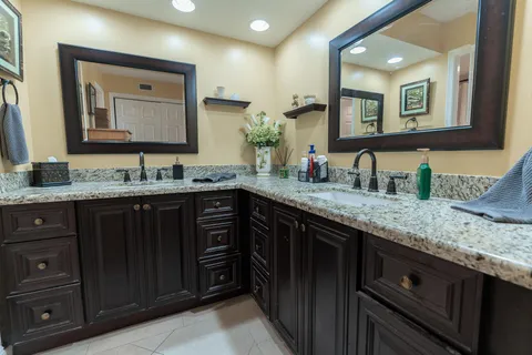 a bathroom with a granite countertop double vanity sink and a mirror