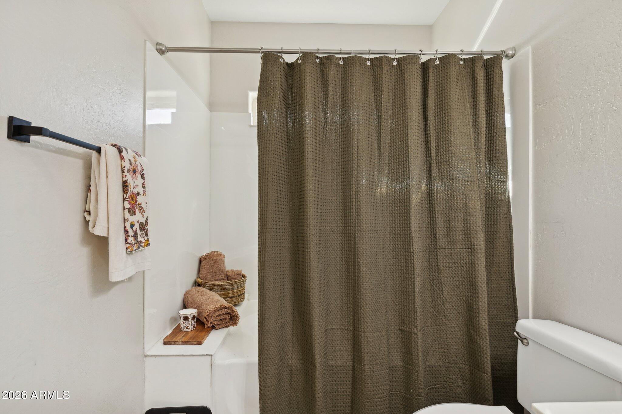 16226 East Fairview Street Gilbert, AZ 85295 - Photo 20 of 59 a bathroom with a shower curtain and a toilet