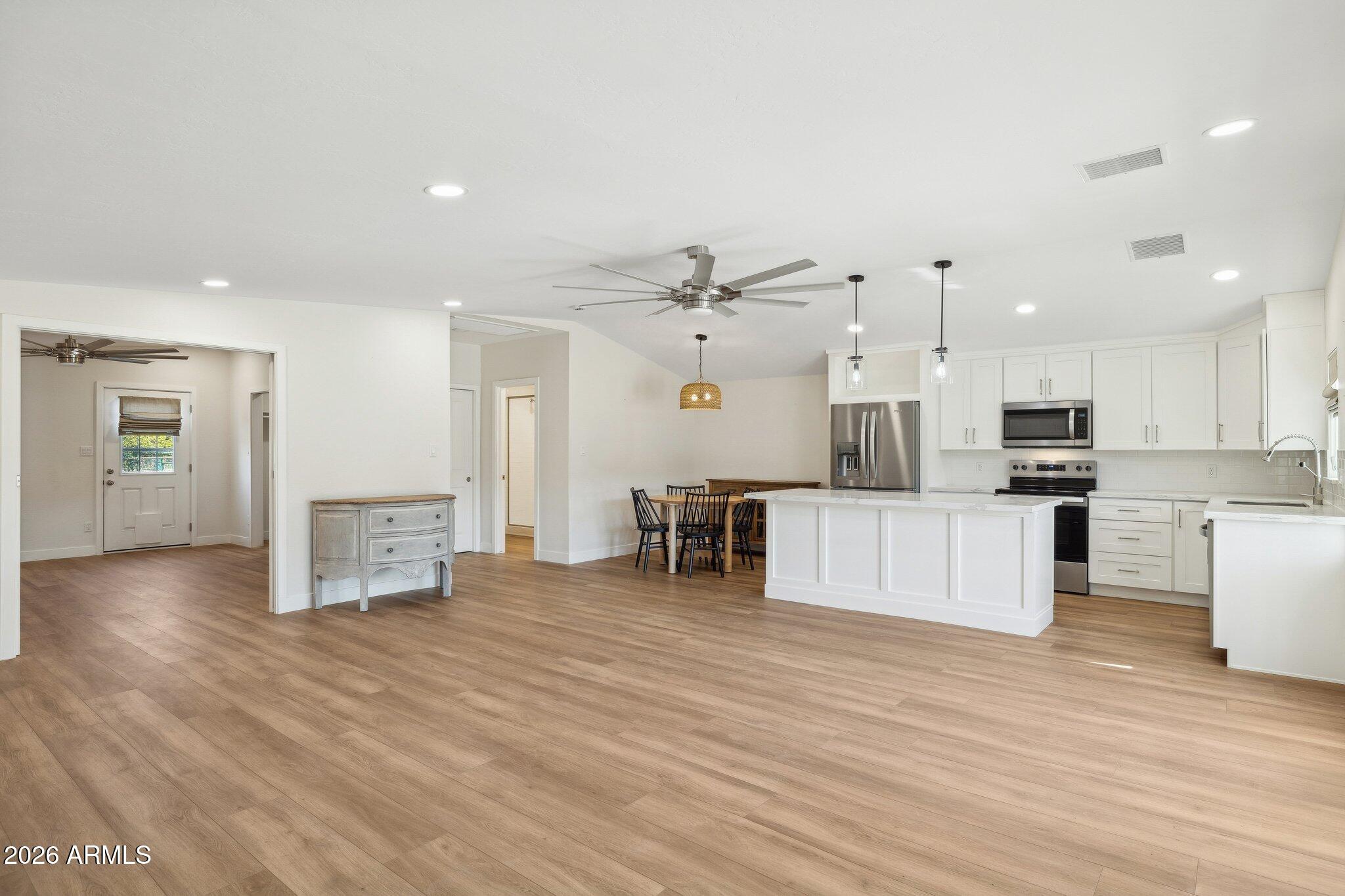 16226 East Fairview Street Gilbert, AZ 85295 - Photo 40 of 59 a large kitchen with cabinets chairs and wooden floor