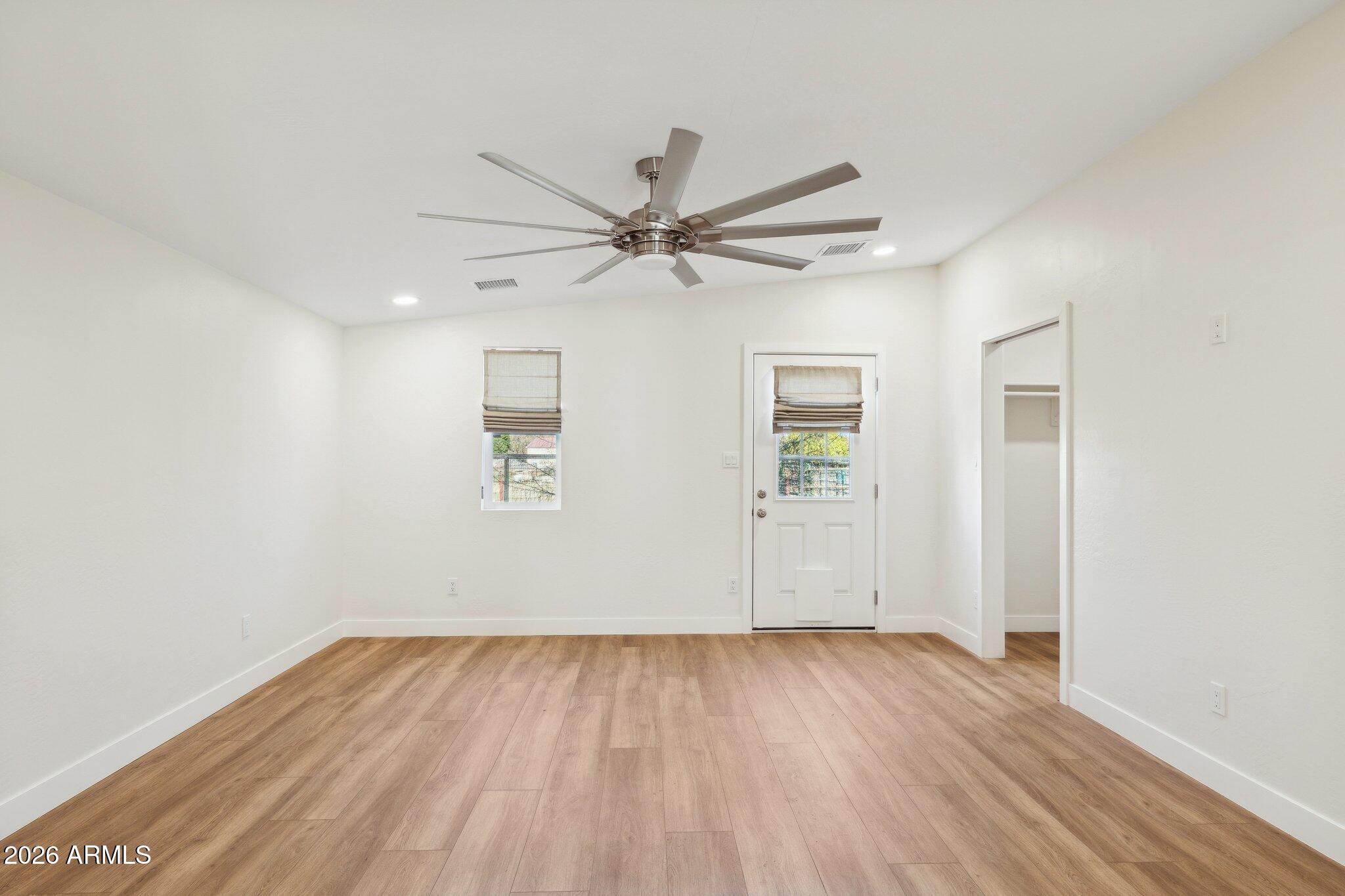16226 East Fairview Street Gilbert, AZ 85295 - Photo 43 of 59 an empty room with wooden floor ceiling fan and windows