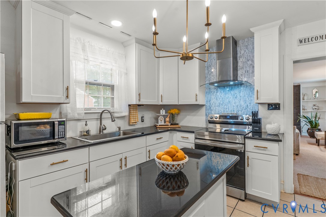 a kitchen with stainless steel appliances granite countertop a sink a stove and a refrigerator