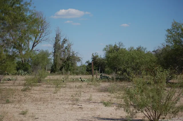a view of dirt road with a building in the background