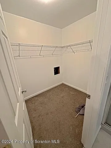 an empty room with windows and ceiling fan