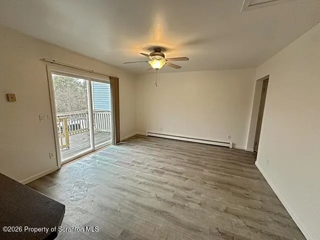 an empty room with windows and chandelier fan