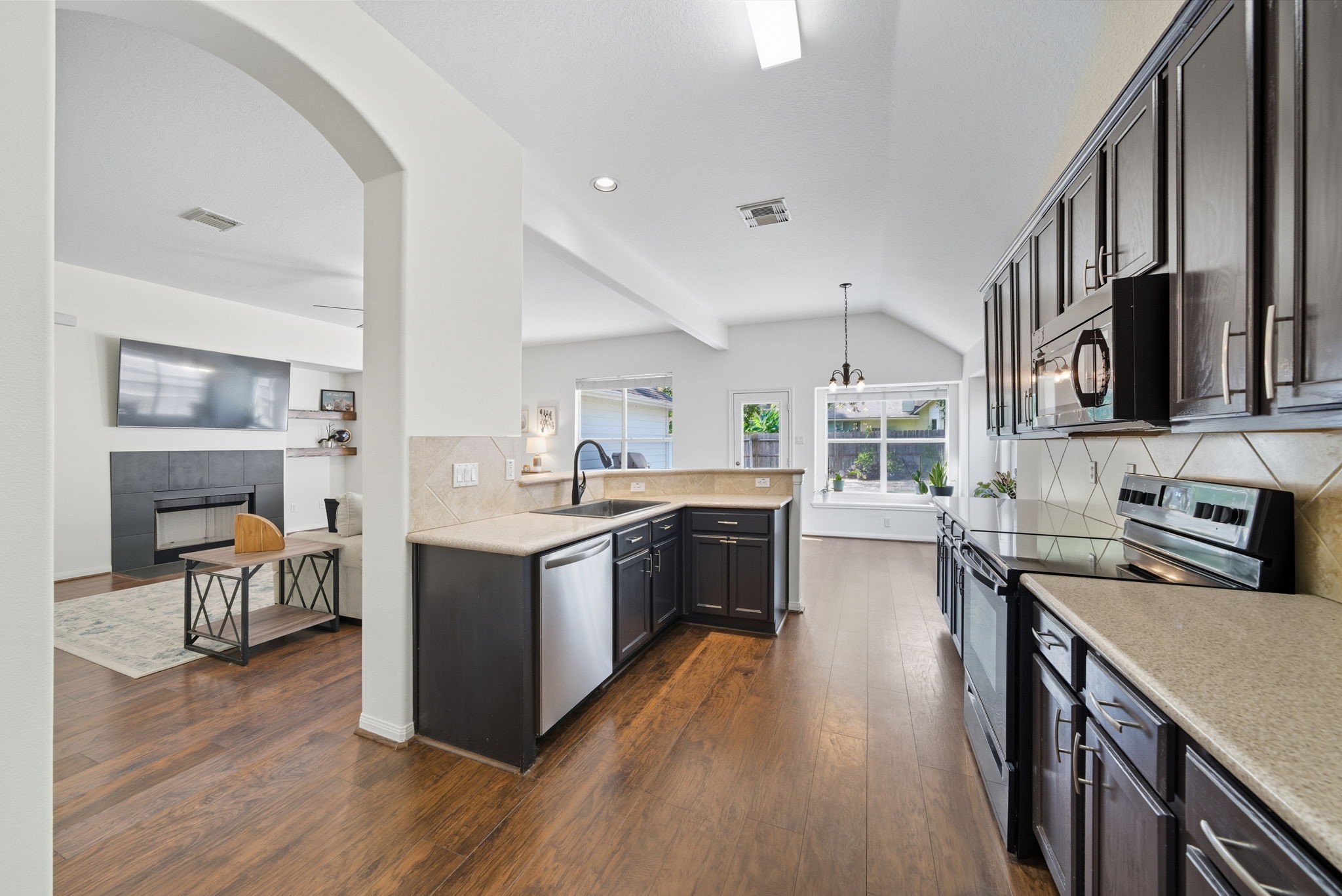 3323 Rollingwood Montgomery, TX 77356 - Photo 9 of 43 a kitchen with stainless steel appliances granite countertop a stove top oven a sink dishwasher and a refrigerator with wooden floor