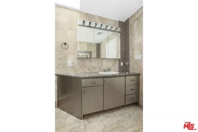 a bathroom with a granite countertop sink and a mirror