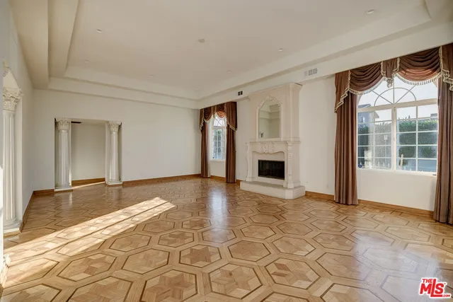 a view of empty room with a fireplace and windows