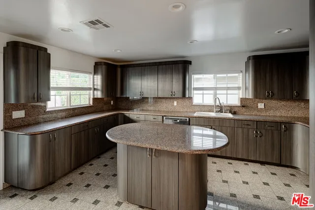 a kitchen with granite countertop a sink stove and cabinets