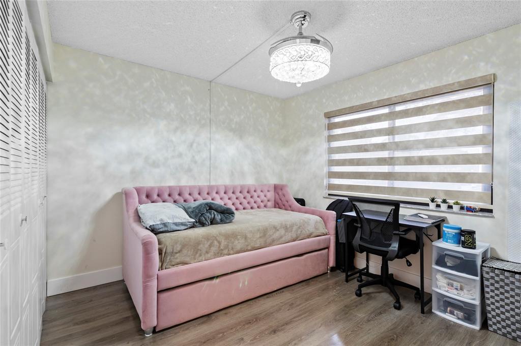 9300 Southwest 8th Street, Unit 102 Boca Raton, FL 33428 - Photo 16 of 23 a living room with furniture and a chandelier