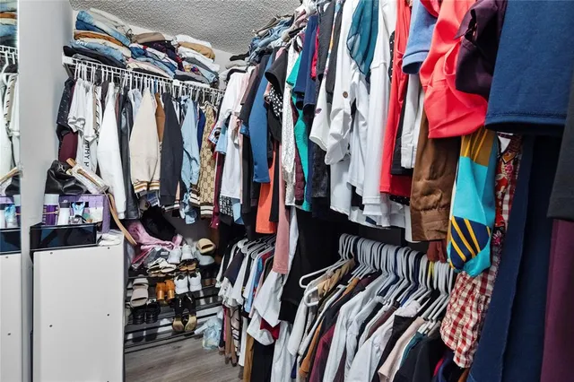 a view of walk in closet with clothes