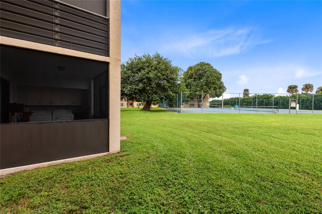 9300 Southwest 8th Street, Unit 102 Boca Raton, FL 33428 - Photo 22 of 23 a backyard of a house with lots of green space