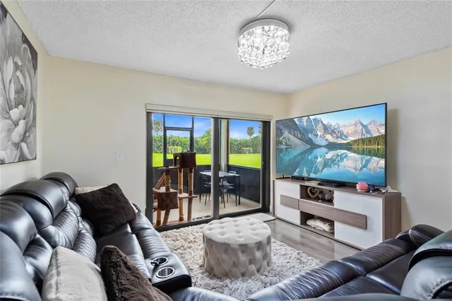 a living room with furniture a floor to ceiling window and a flat screen tv