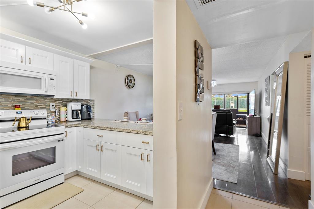 9300 Southwest 8th Street, Unit 102 Boca Raton, FL 33428 - Photo 7 of 23 a kitchen with cabinets and wooden floor