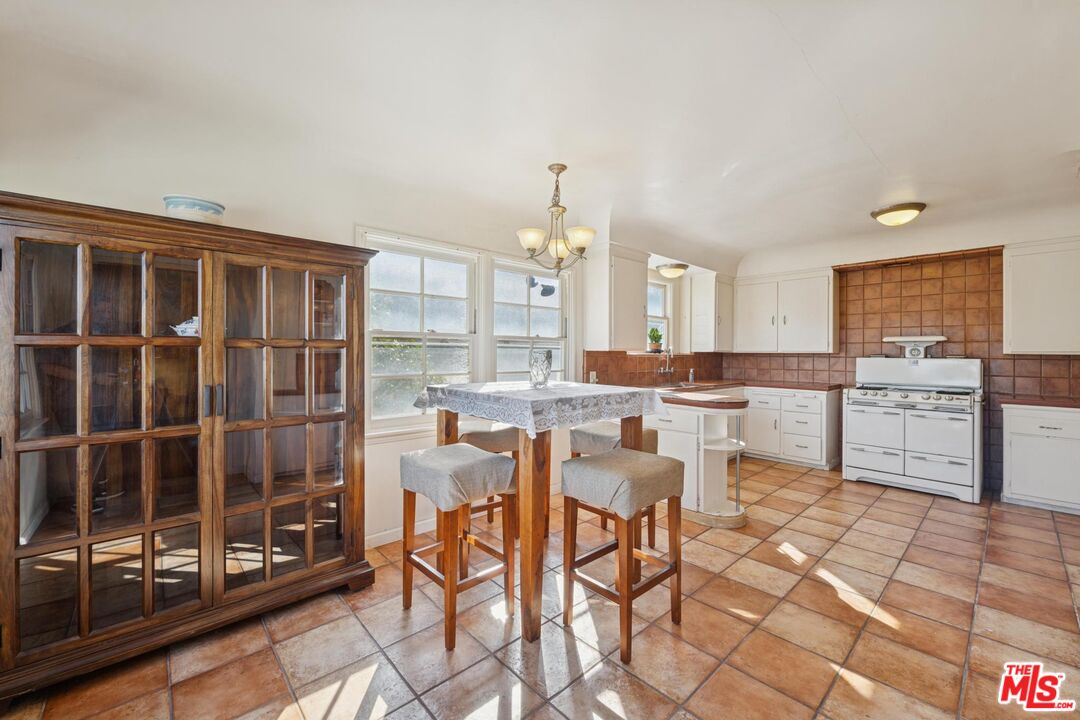 5002 Valley Ridge Avenue View Park, CA 90043 - Photo 14 of 44 a kitchen with a dining table chairs and large window