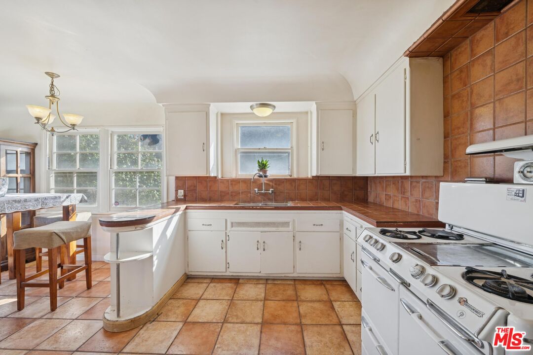 5002 Valley Ridge Avenue View Park, CA 90043 - Photo 17 of 44 a kitchen with a sink stove and cabinets