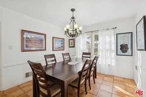 a view of a dining room with furniture a chandelier and wooden floor