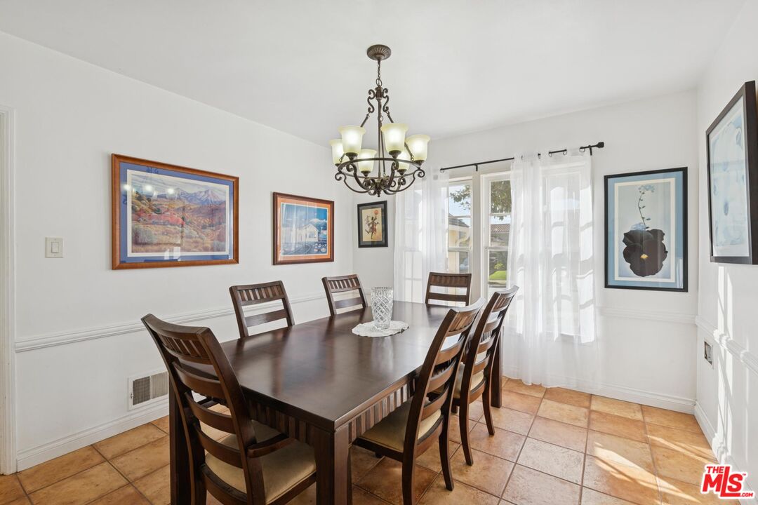 5002 Valley Ridge Avenue View Park, CA 90043 - Photo 9 of 44 a view of a dining room with furniture a chandelier and wooden floor