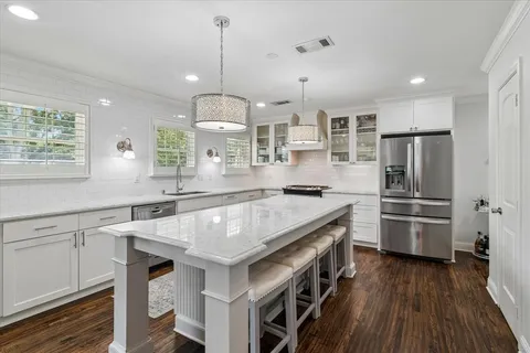 a kitchen with a center island wooden floor and stainless steel appliances