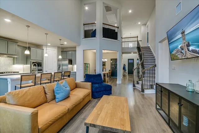 a living room with furniture kitchen view and a wooden floor