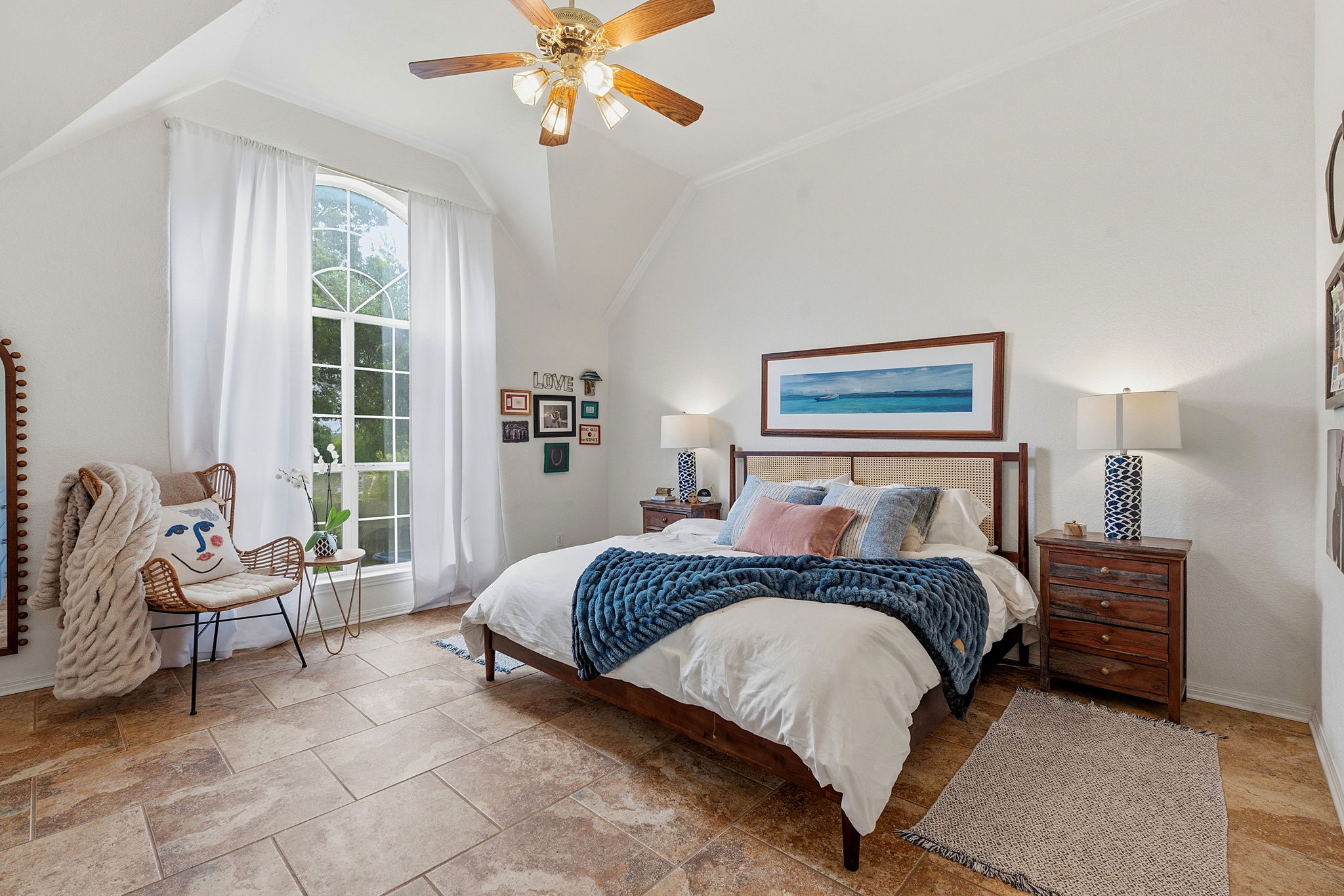 8317 Pommel Drive Austin, TX 78759 - Photo 11 of 26 An inviting primary bedroom featuring vaulted ceilings and a grand arched window, creating an open and airy retreat.