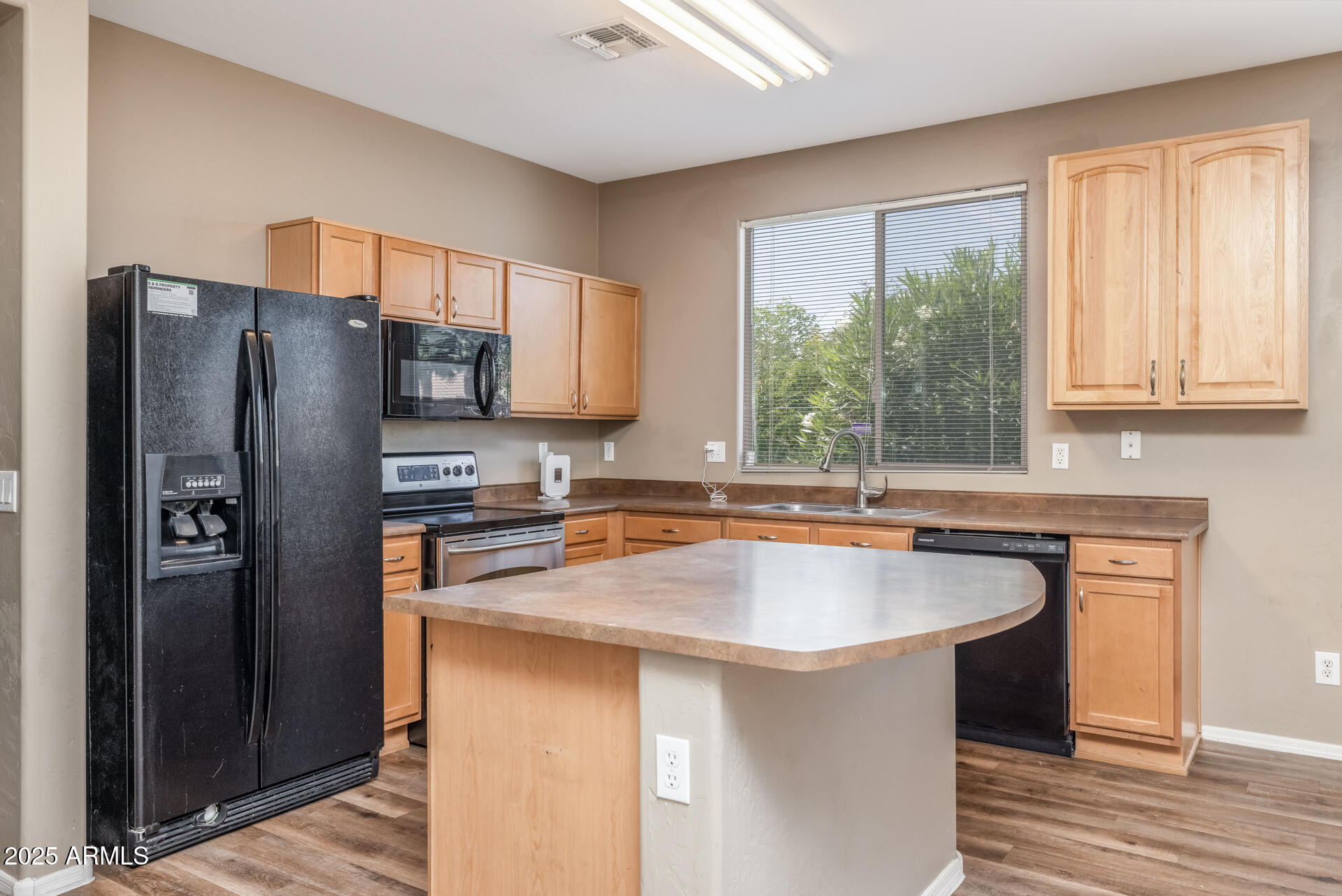 3148 West Maldonado Road Phoenix, AZ 85041 - Photo 8 of 31 a kitchen with stainless steel appliances granite countertop a refrigerator a sink a stove a washer dryer and white cabinets