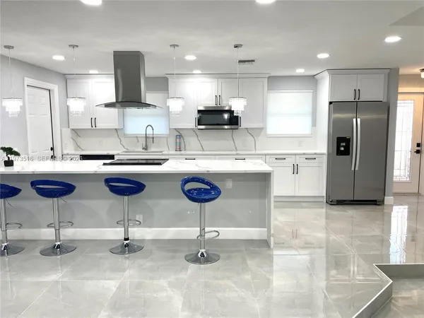 a kitchen with stainless steel appliances kitchen island granite countertop a sink and cabinets