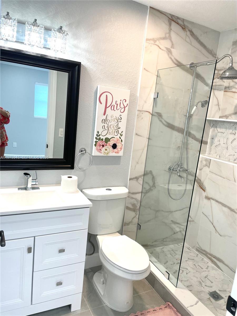 1280 West Camino Real, Unit 1280 Boca Raton, FL 33486 - Photo 17 of 26 a bathroom with a sink vanity mirror and toilet