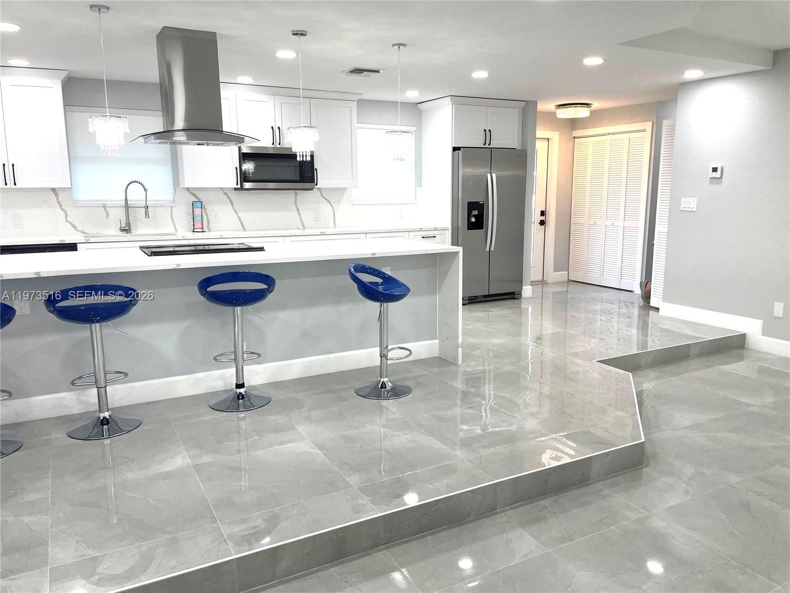 1280 West Camino Real, Unit 1280 Boca Raton, FL 33486 - Photo 2 of 26 a kitchen with stainless steel appliances kitchen island granite countertop a sink and cabinets