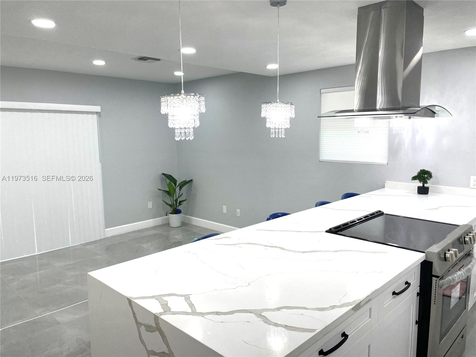 1280 West Camino Real, Unit 1280 Boca Raton, FL 33486 - Photo 4 of 26 a kitchen with a sink chandelier and wooden floor