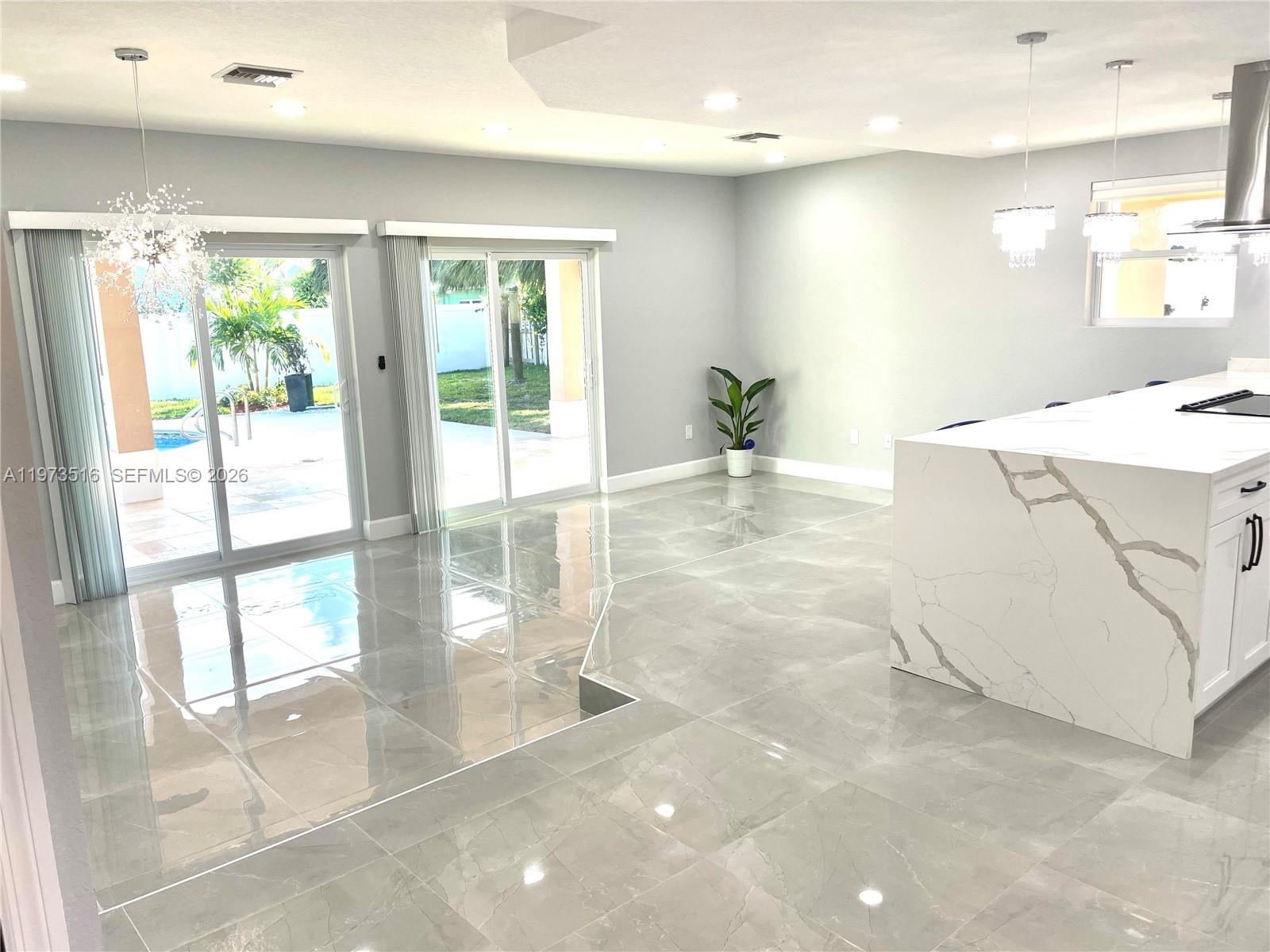 1280 West Camino Real, Unit 1280 Boca Raton, FL 33486 - Photo 6 of 26 a view of a kitchen with kitchen island a large window a sink and a counter space