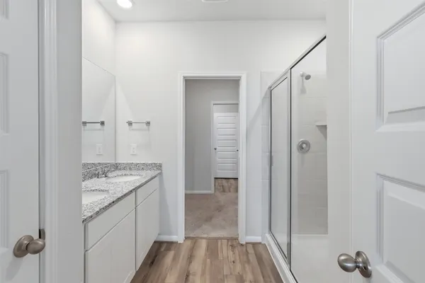 a bathroom with a granite countertop sink a mirror and a shower