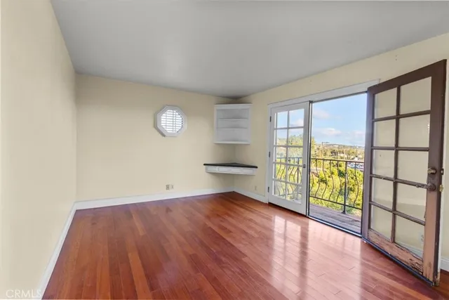 a walk in closet with wooden floor