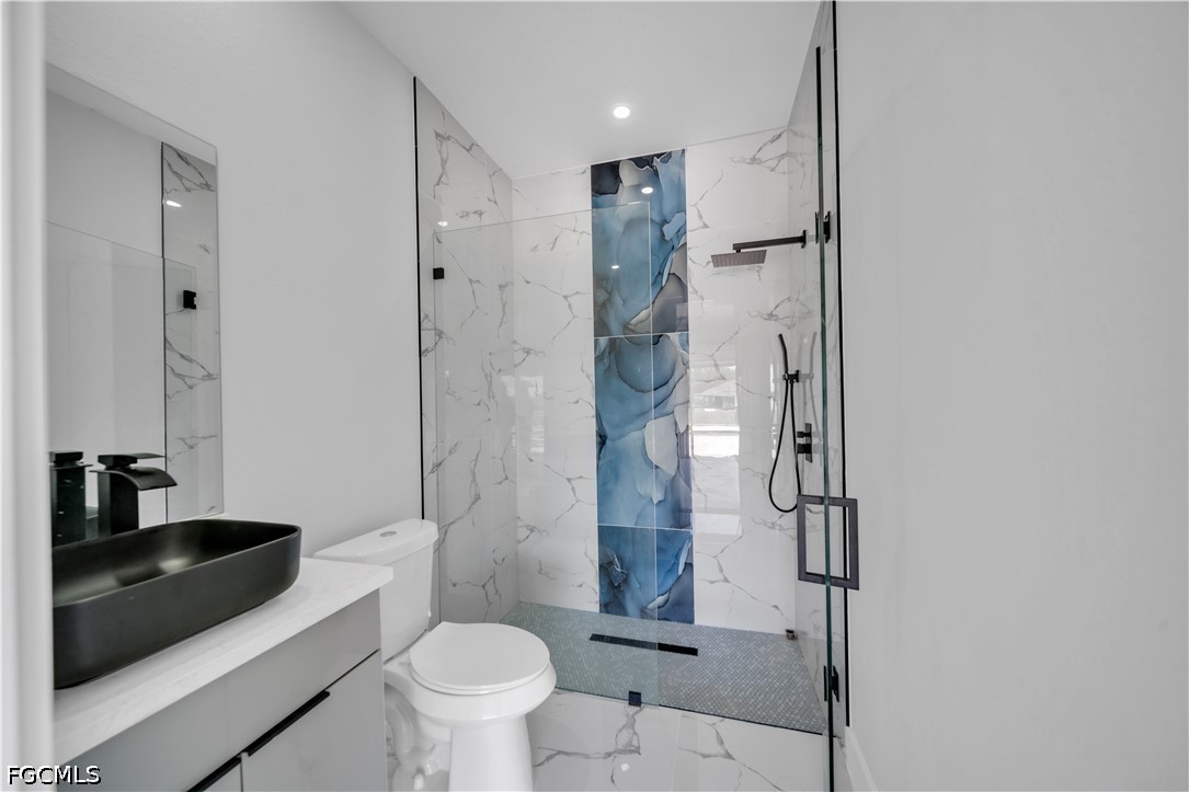 1128 Nelson Road North Cape Coral, FL 33993 - Photo 19 of 22 a bathroom with a sink a toilet and shower