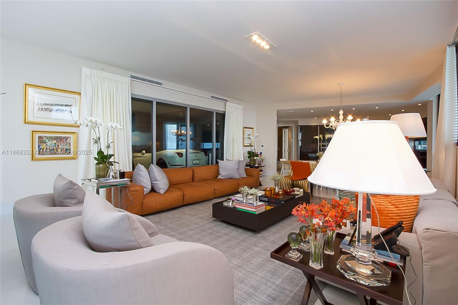 18555 Collins Avenue, Unit 4605 Sunny Isles Beach, FL 33160 - Photo 13 of 40 a living room with furniture and a flat screen tv