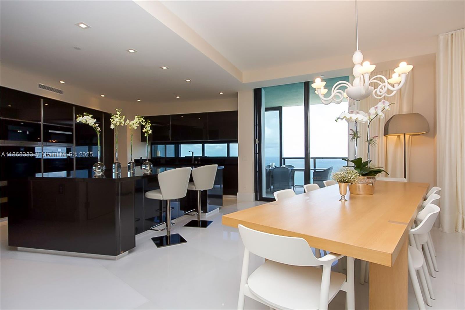 18555 Collins Avenue, Unit 4605 Sunny Isles Beach, FL 33160 - Photo 15 of 40 a dining room with furniture and a chandelier