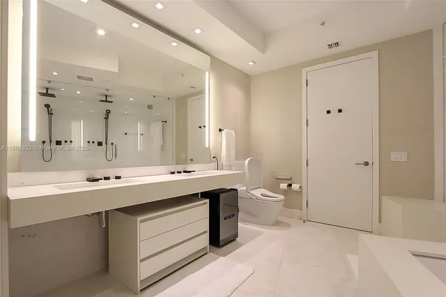 a spacious bathroom with a bathtub shower sink double and mirror