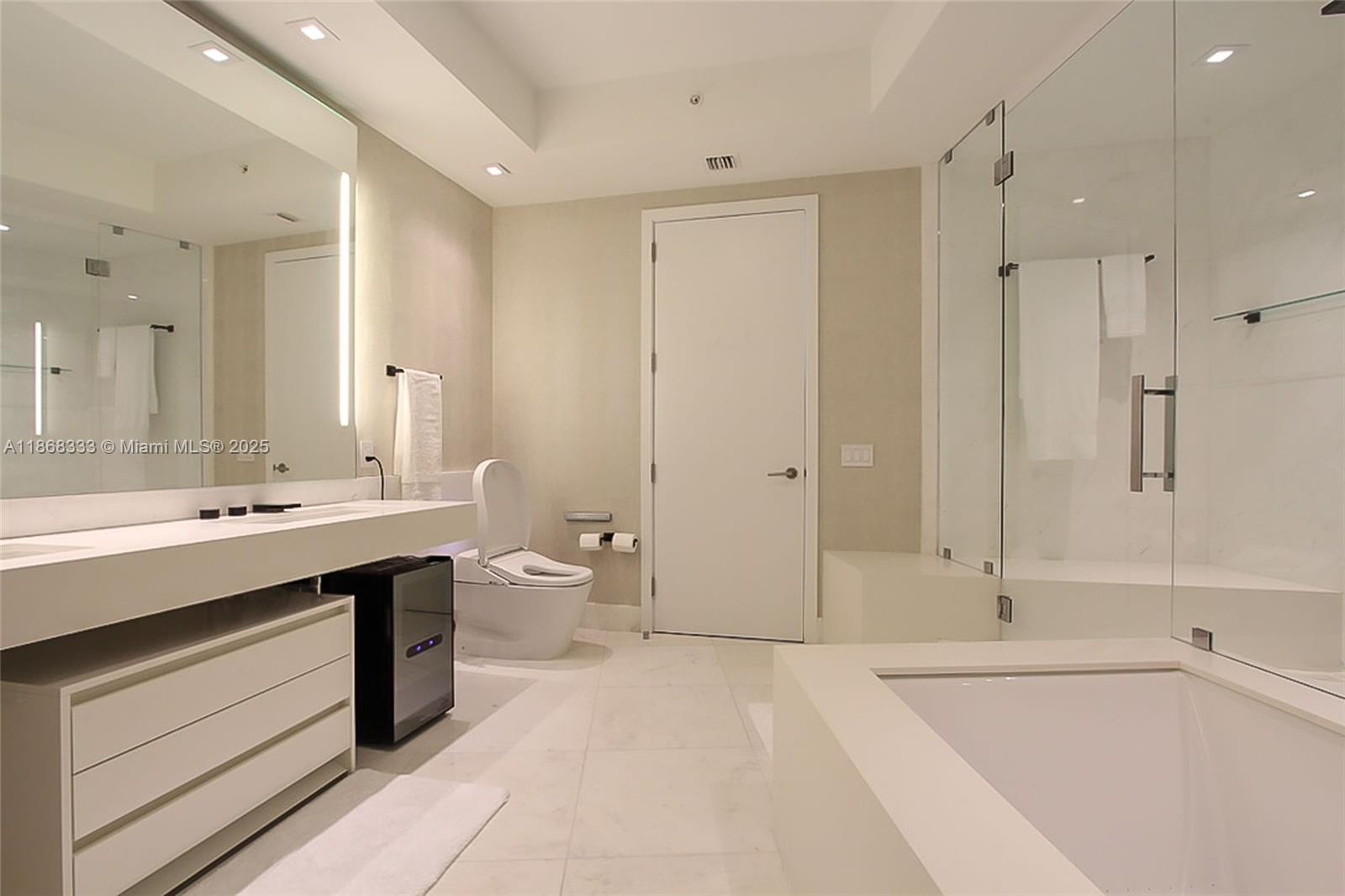 18555 Collins Avenue, Unit 4605 Sunny Isles Beach, FL 33160 - Photo 22 of 40 a spacious bathroom with a bathtub shower sink double and mirror