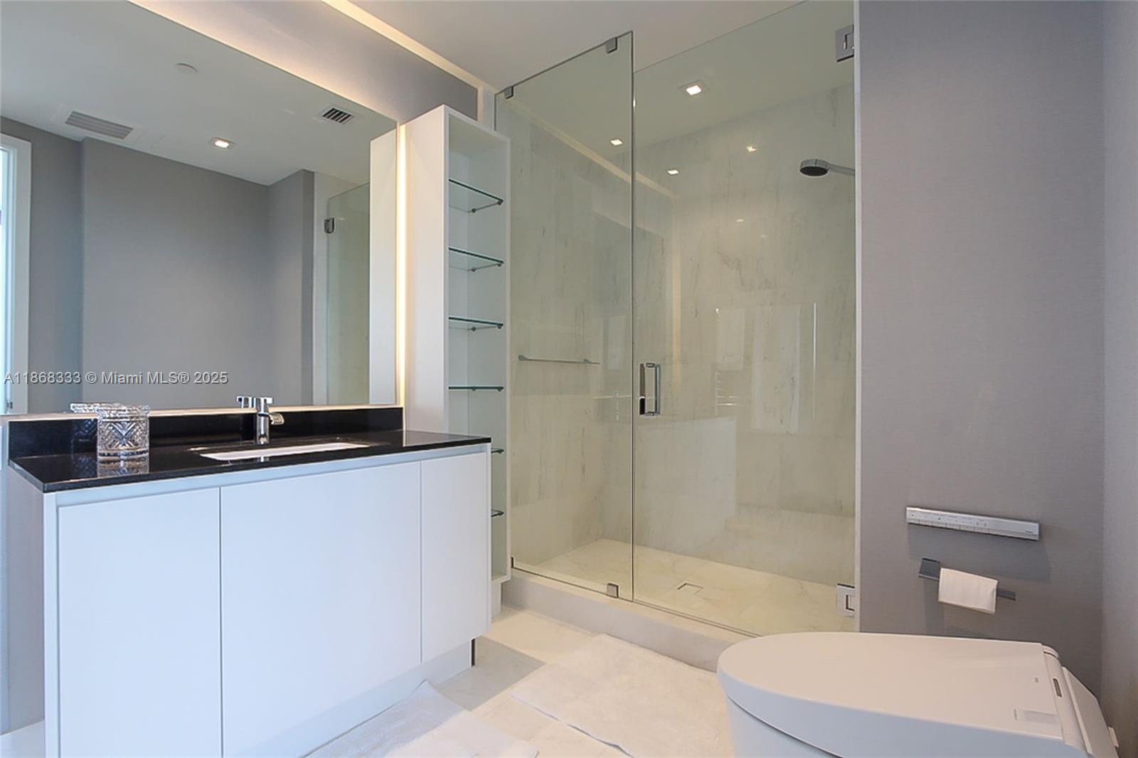 18555 Collins Avenue, Unit 4605 Sunny Isles Beach, FL 33160 - Photo 23 of 40 a bathroom with a granite countertop sink mirror vanity and toilet