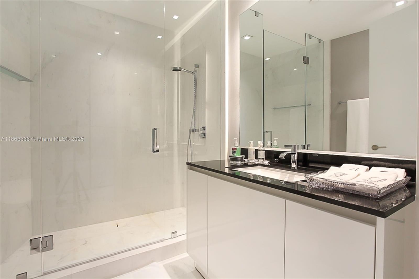 18555 Collins Avenue, Unit 4605 Sunny Isles Beach, FL 33160 - Photo 24 of 40 a bathroom with a granite countertop sink and a mirror